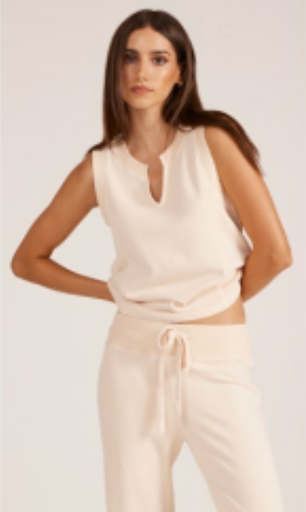 Woman wearing white tank top on white background.