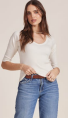 Woman in white long sleeve and blue jeans on white background.