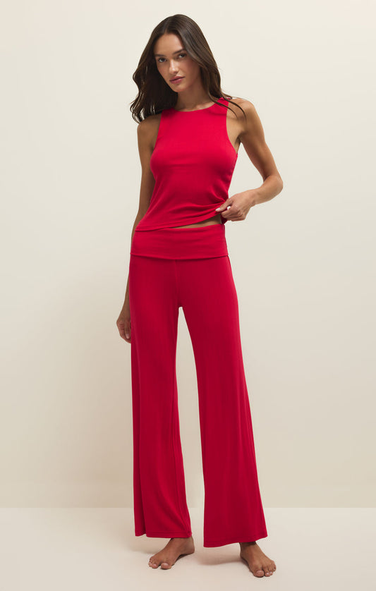 Woman wearing a red sleeveless top and wide-leg pants on a white background