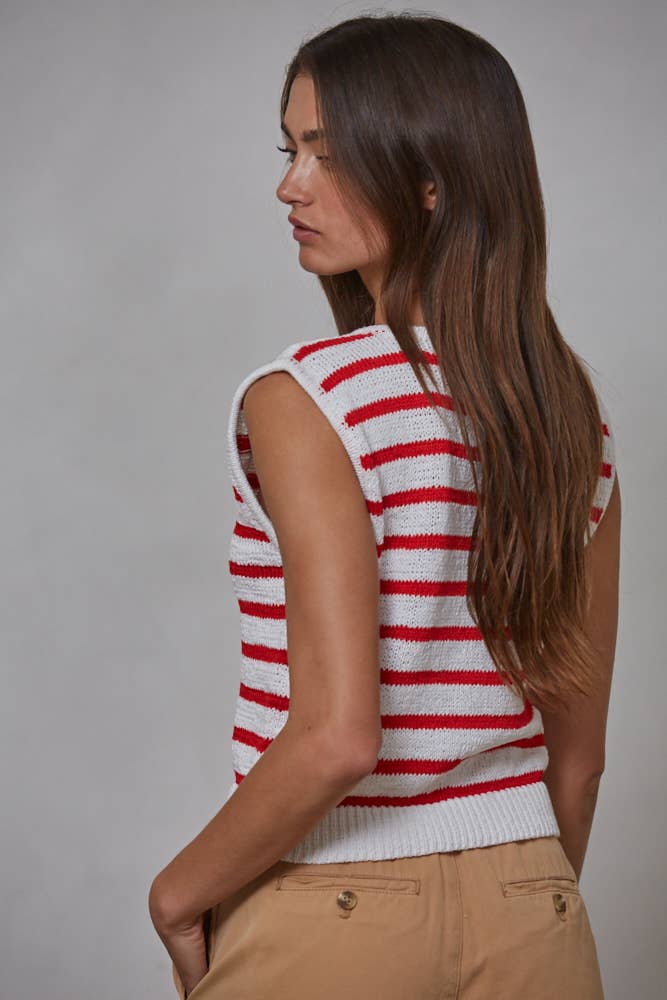 Woman wearing a red and white striped sleeveless sweater against a gray background