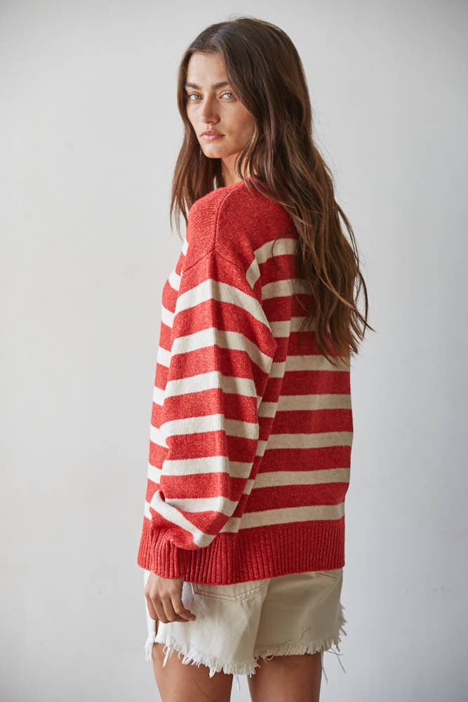 Woman wearing a red and white striped sweater against a plain background
