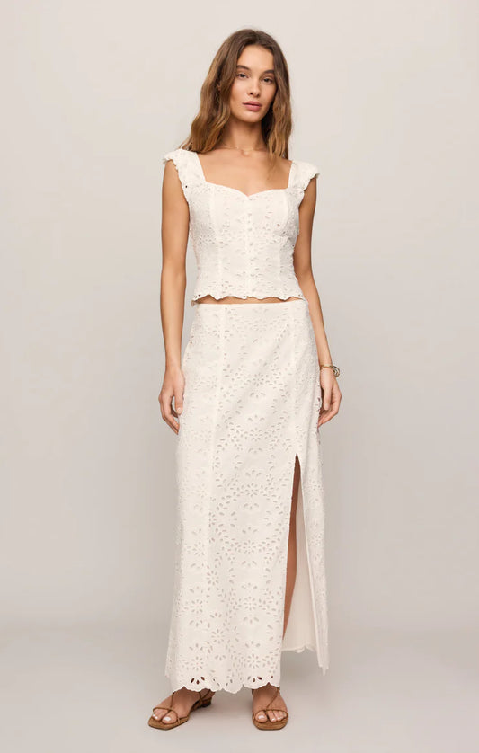 Woman wearing a white lace dress with a plain background