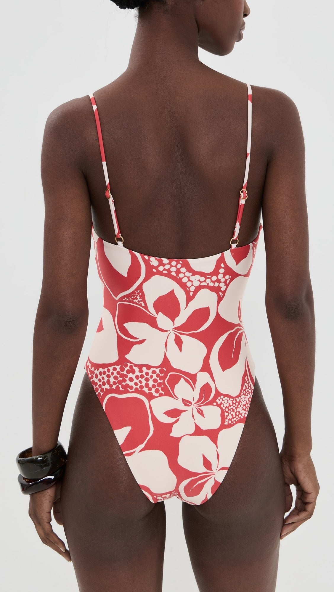 Woman in red one piece bathing suit on white background.