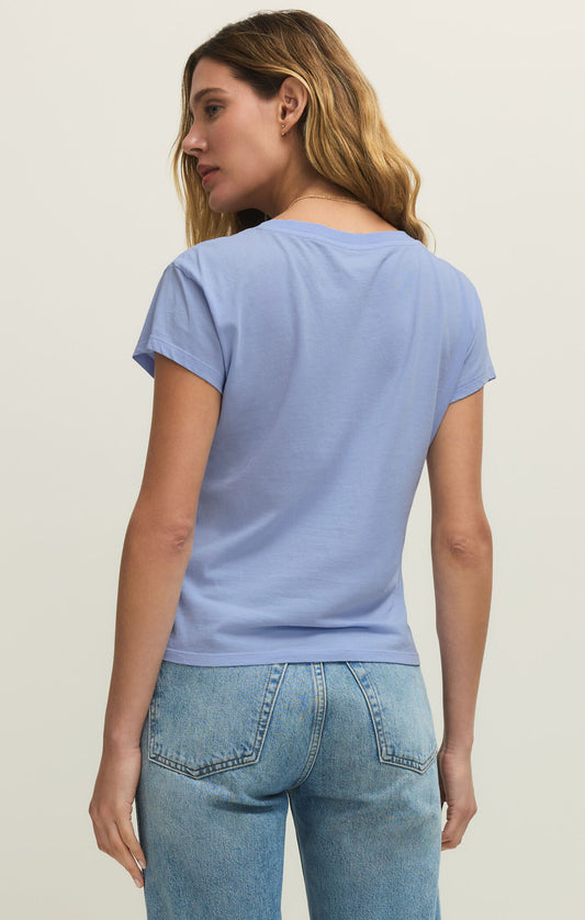 Woman wearing a light blue t-shirt and jeans on a plain background