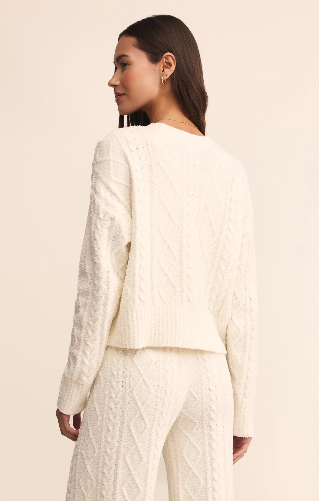 Woman wearing a white textured outfit on a beige background