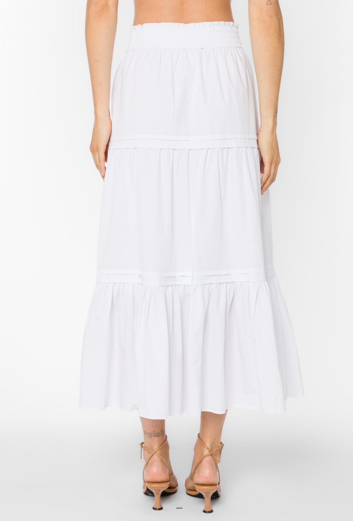 White tiered skirt worn by a person on a white background