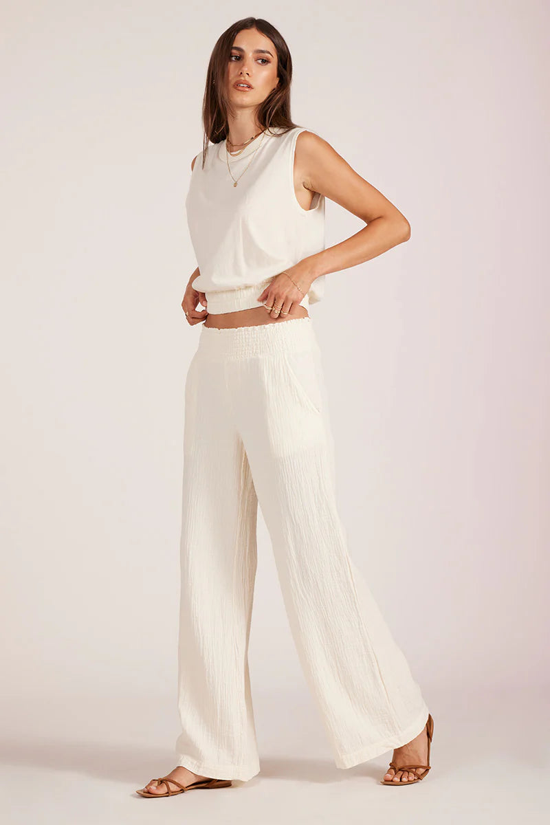Woman wearing a white outfit on a plain background