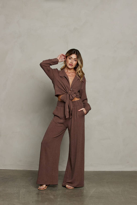 Woman wearing a brown outfit against a plain background