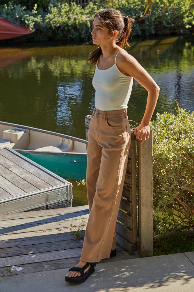 Woman standing by a dock with a boat in the background