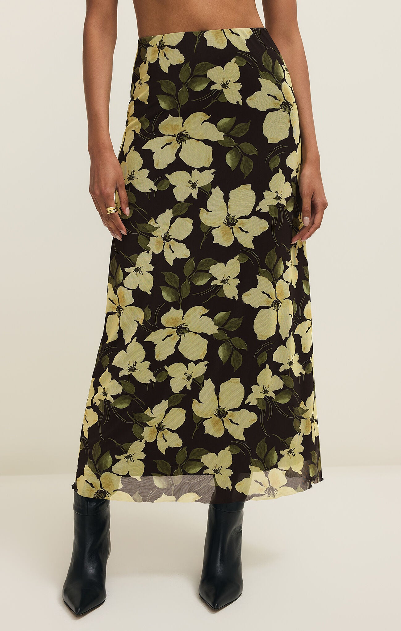 Person wearing a floral skirt with a plain background