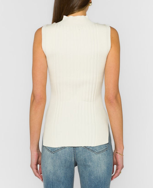 A woman shown from the back wearing a sleeveless, ribbed knit mock neck top in off-white, paired with blue jeans, against a light gray studio background.