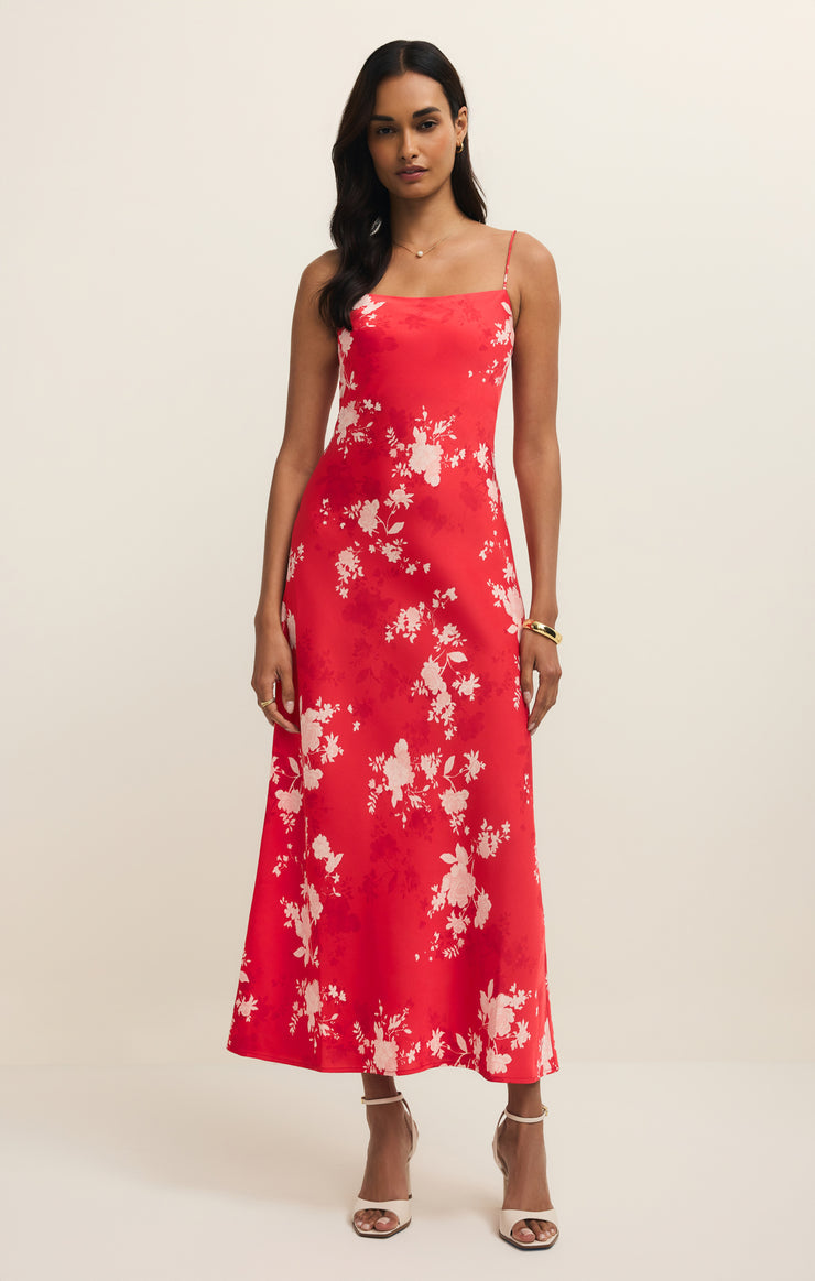 Woman wearing a red floral dress on a beige background