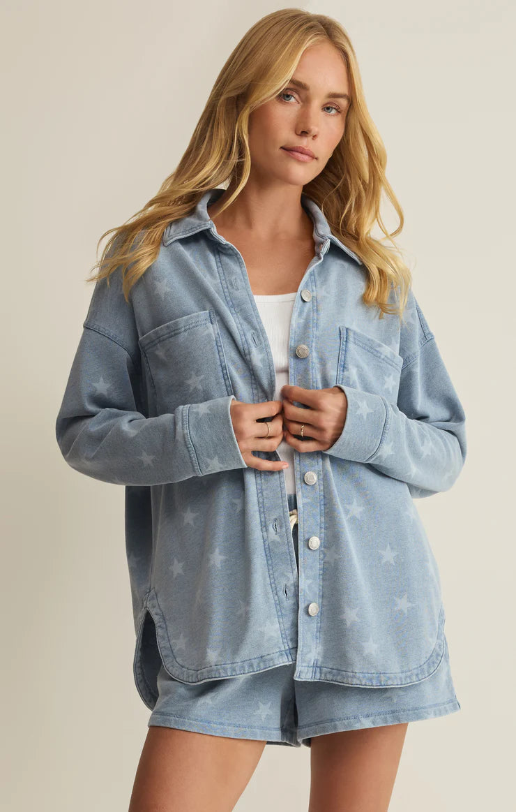 Woman wearing a light blue denim jacket on a beige background