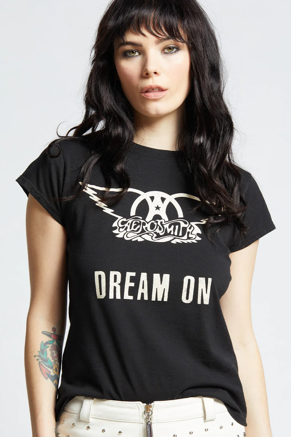 Woman in black tee shirt that says Dream On in a white background.