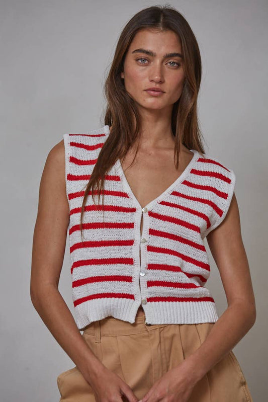 Woman wearing a red and white striped knitted vest against a gray background