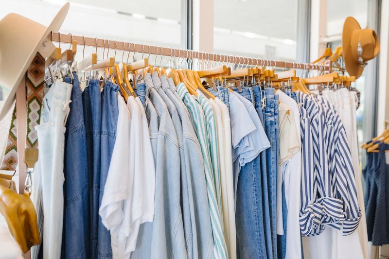 Clothing rack with various shirts and jeans in a store setting