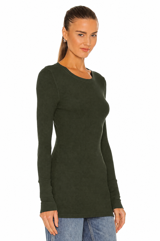 Woman in green long sleeve thermal top and blue jeans on white background.