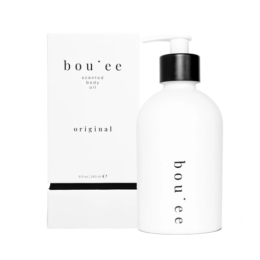 Container with pump of body oil labeled 'boujee' on a white background.