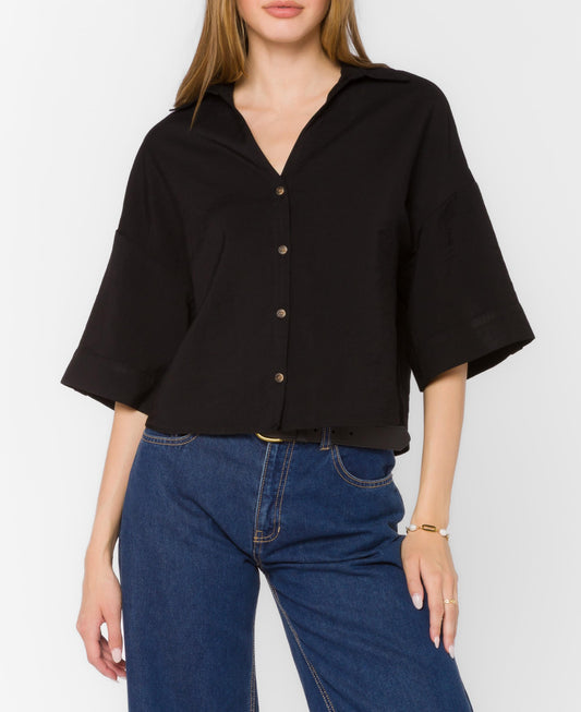 Person wearing a black shirt and blue jeans on a white background