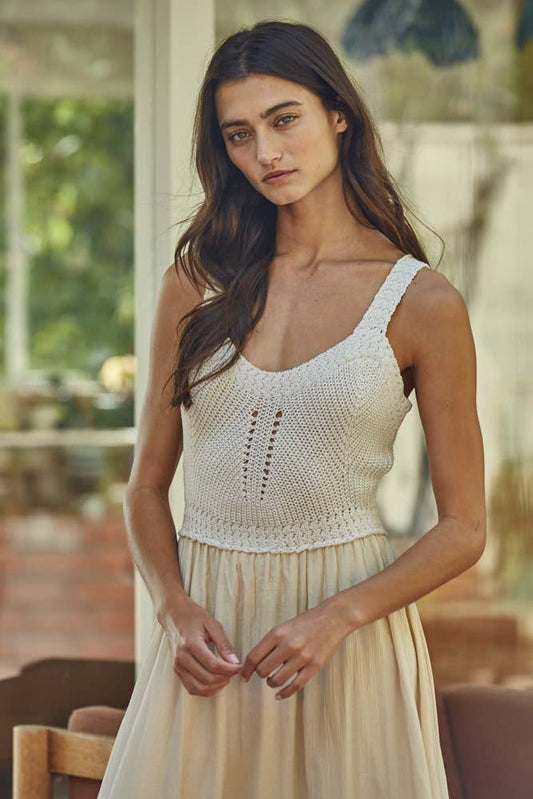 Woman wearing a white crochet top and beige skirt outdoors