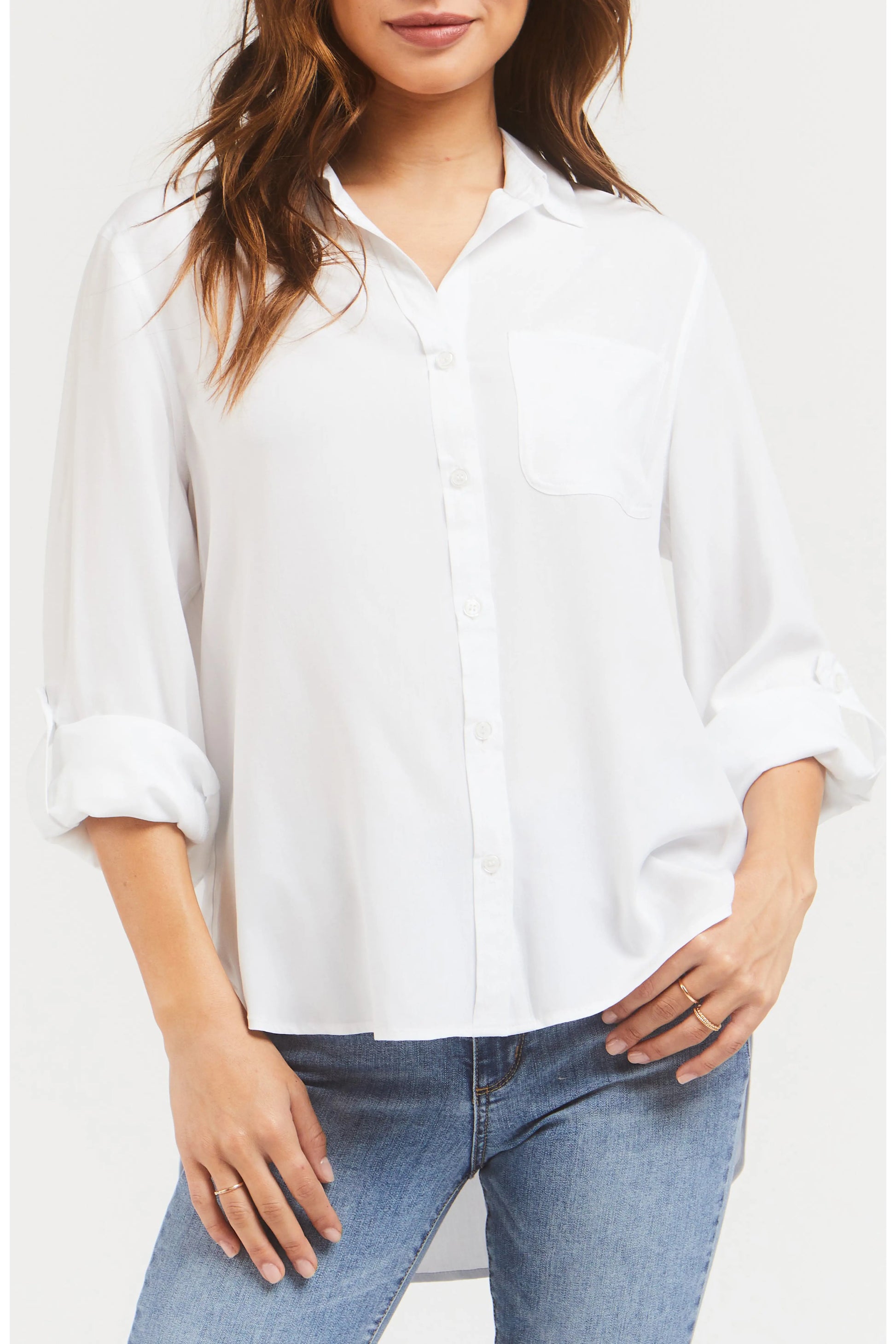 Person wearing a white shirt and blue jeans on a plain background