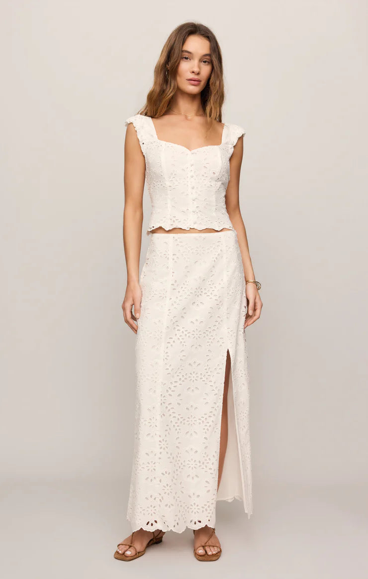 Woman wearing a white lace dress with a plain background