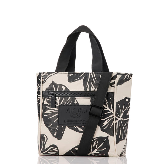 Tote bag with black leaf pattern and black strap on a white background