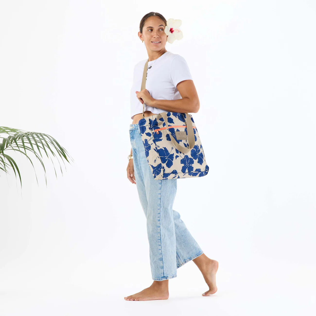 Woman holding a floral-patterned bag against a white background
