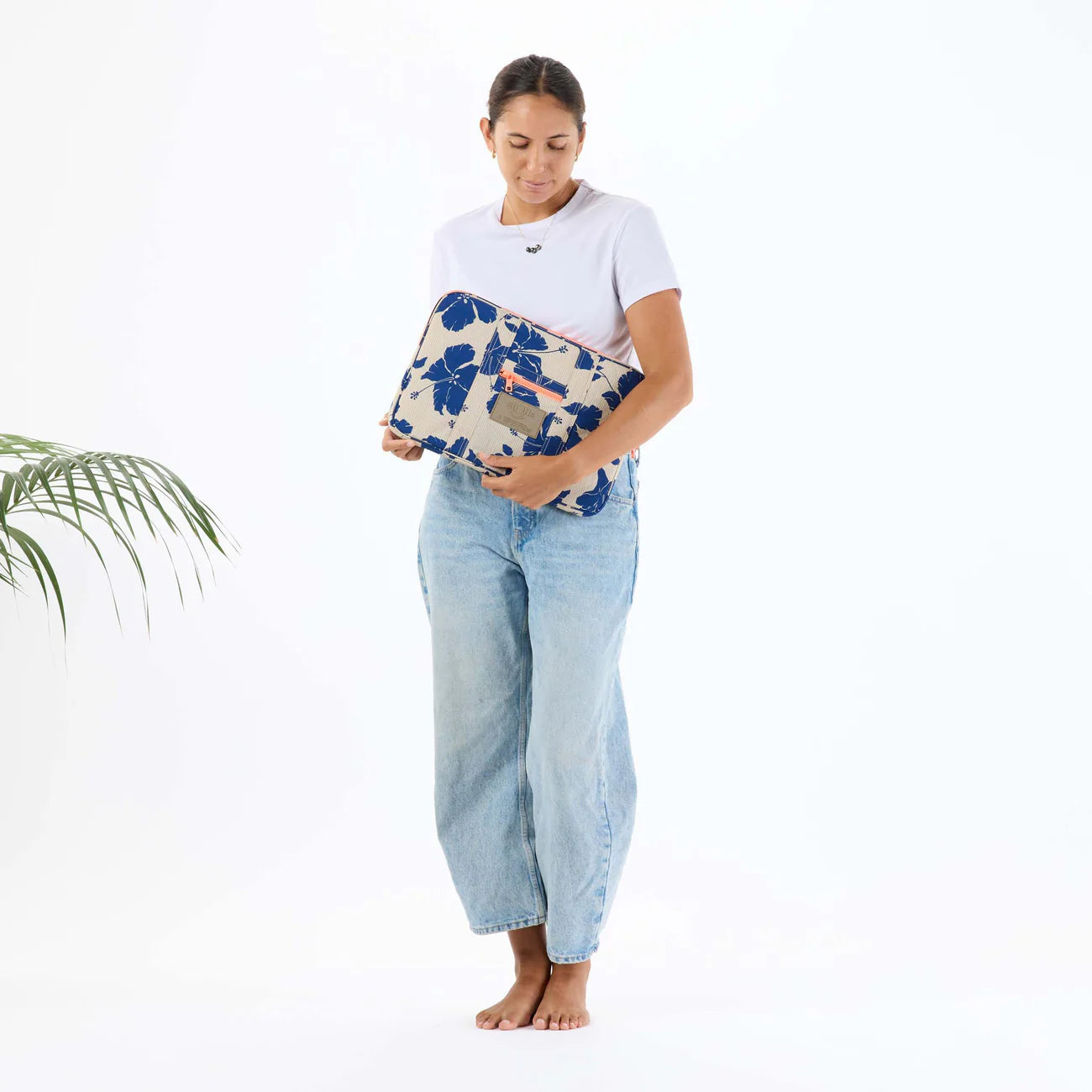 Woman holding a floral-patterned bag against a white background