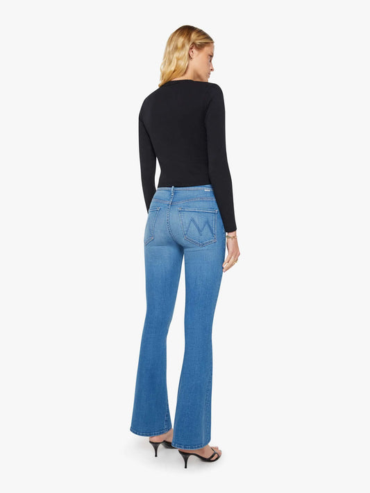 Woman wearing blue jeans and a black top on a white background