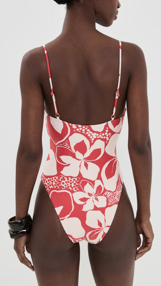 Woman in red one piece bathing suit on white background.