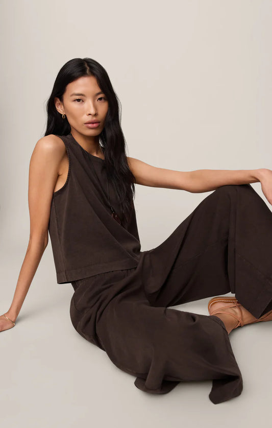 Woman sitting in dark brown set on a white background.