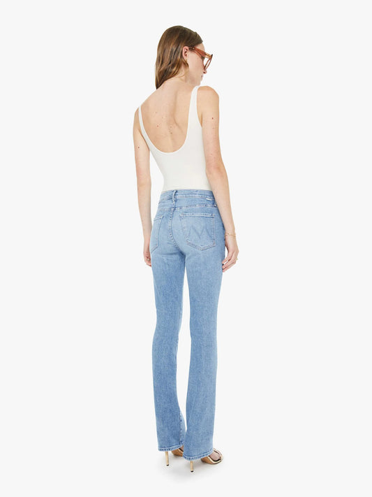 Woman wearing light blue jeans and a white top on a white background